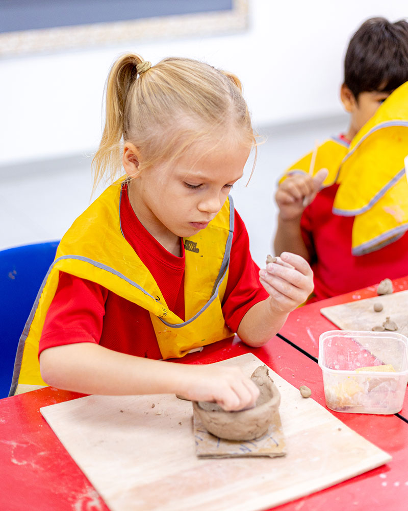 OFS Kindergarten student playing with clay during art session
