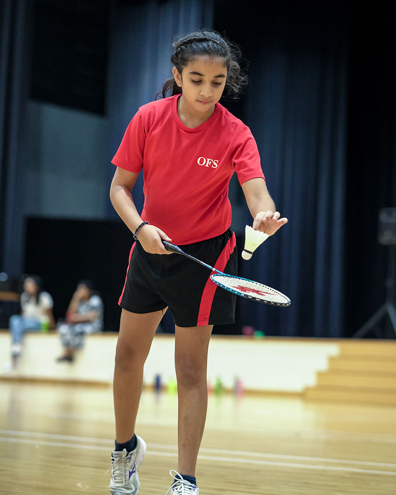 OFS Elementary School student serving the shuttle cock during badminton practice