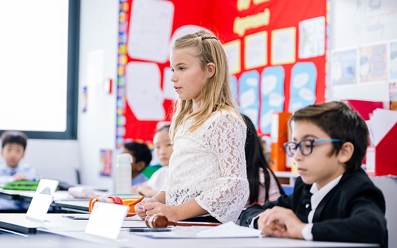 A female OFS Elementary School student giving speech in the classroom during OFS Primary Years Model United Nations (PY-MUNOFS)