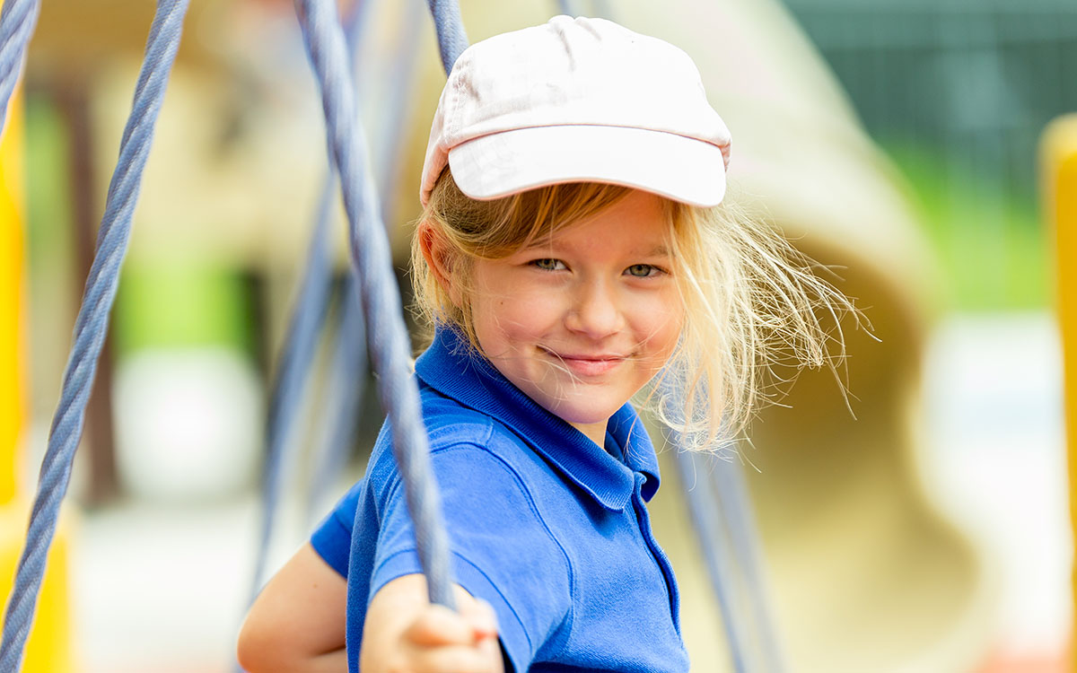 A female OFS Kindergarten students standing in the playground
