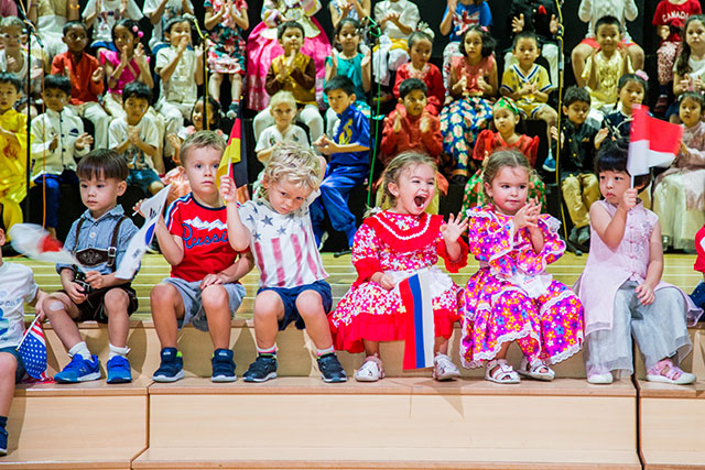 OFS Kindergarten students sitting on the auditorium stage
