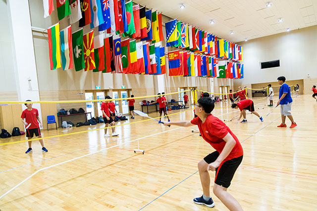 OFS High School students playing badminton in the auditorium