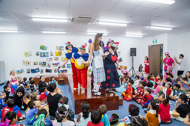 OFS Kindergarten teachers in book character costumes on the catwalk while students watch