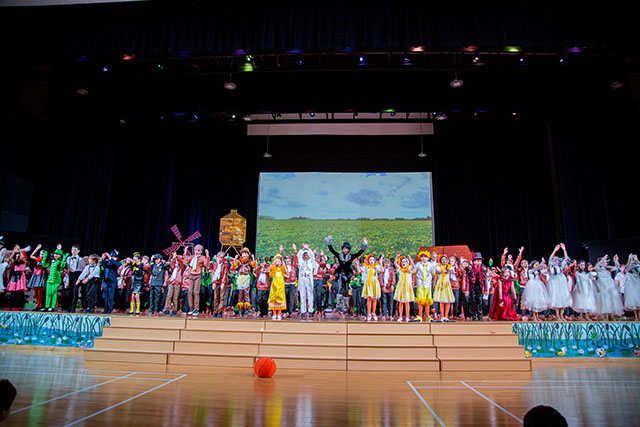 OFS Elementary School students performing Honk Jr. Musical on the auditorium stage