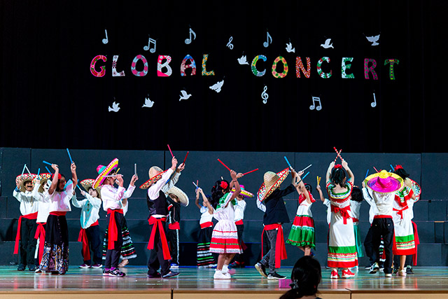 OFS Elementary School students performing dance routine on the auditorium stage