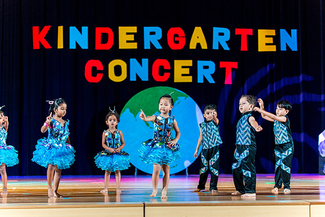 OFS Kindergarten K1 students performing dance routine on the auditorium stage