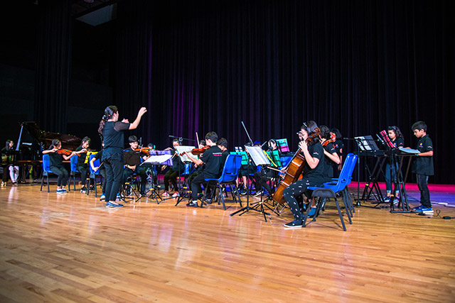 OFS Elementary School symphony performing on the auditorium stage
