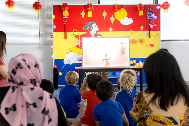 OFS Kindergarten teachers, parents and students watching chinese puppet show