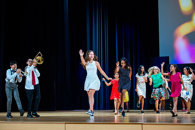 OFS Middle School students performing songs and dance on the auditorium stage