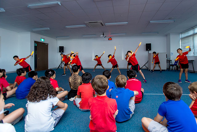 OFS Elementary School Grade 4 students performing in the activity room during Mother Tongue Assembly