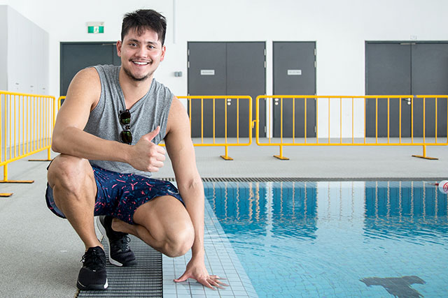 Joseph Schooling posing for the camera next to OFS swimming pool