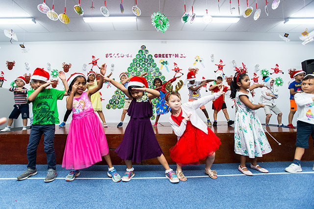 OFS Kindergarten students dancing and singing chrismast songs on the stage in activity room